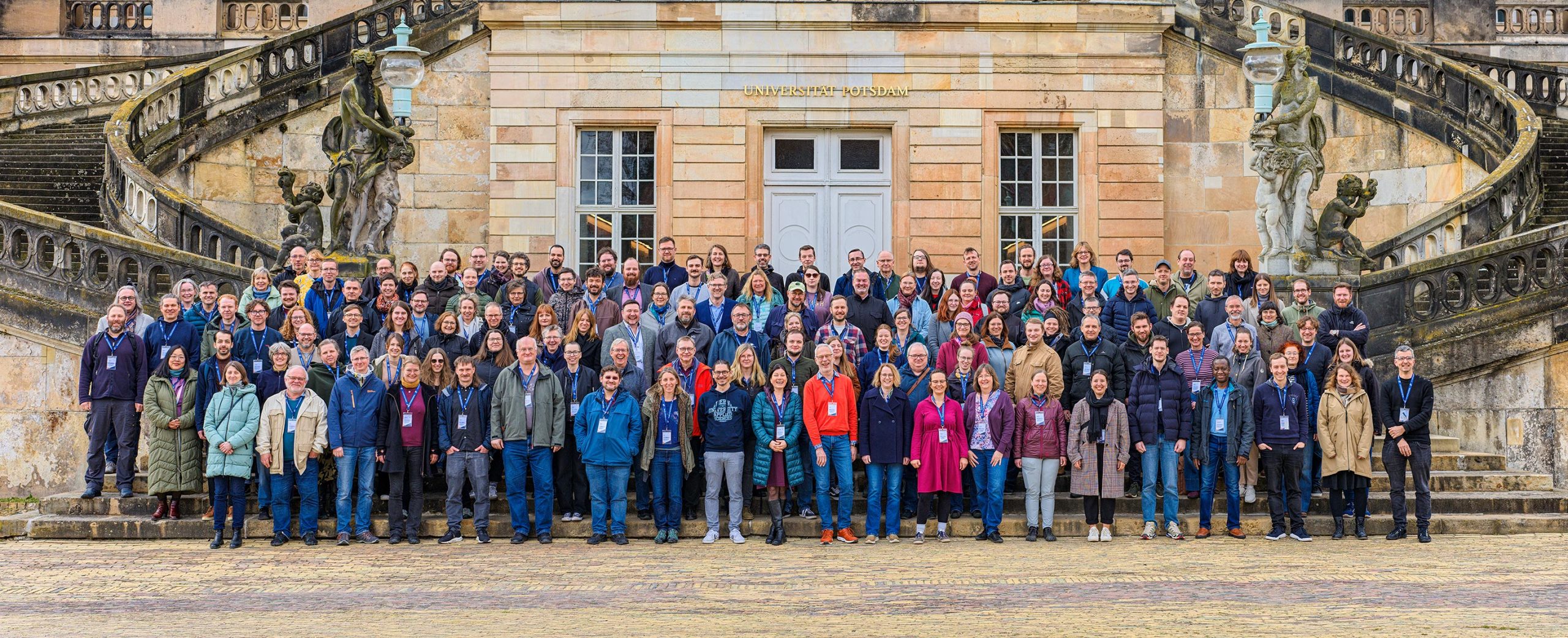 Gruppenfoto aller Teilnehmenden vor dem Neuen Palais